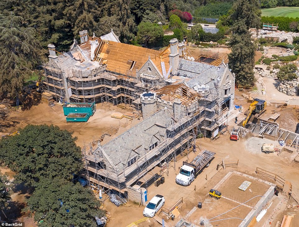 New aerial photos show the enormous amount of work being carried out on the grounds of the Playboy mansion in Beverly Hills as a new roof is installed and a digger and flatbed truck work to clear some land at  the side of the house