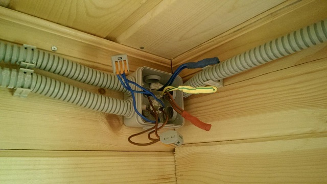 Применение гофрированной трубы-оболочки для прокладки открытой электропроводки в деревянном доме.