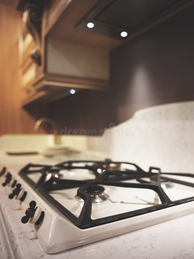 Interior of modern classic beige wooden kitchen macro close-up gas cooker vertical image.  stock photo